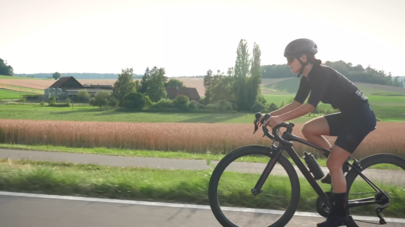 Amateur cyclist riding a bike with a picturesque background. How Far Can You Bike In A Day?