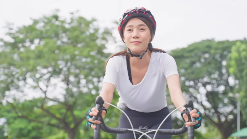 Young Asian Woman Riding a Bike. Concept for Enjoying while cycling.