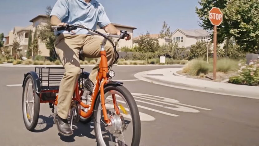 A person riding an adult tricycle. Concept for Different Uses of Tricycles in Everyday Life