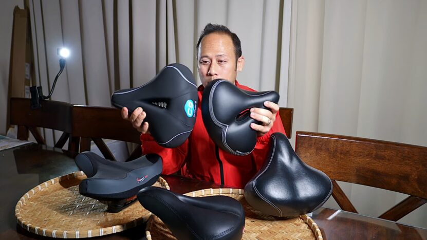 An Asian Person Inspecting Different Bike Seats. Choosing the Right Bike Seat for Your Needs